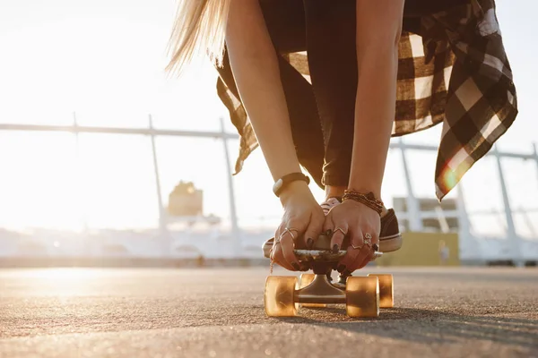 Hipster piernas de niña y manos con anillos en una tabla de skate —  Fotos de Stock