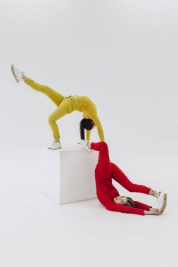 Beyaz küp üzerinde iki kadın