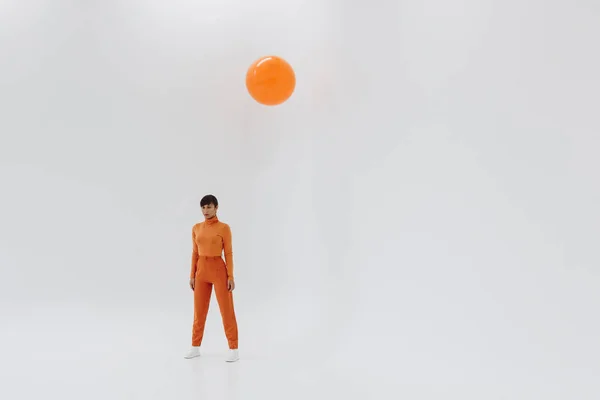 Woman in orange clothes  on white background — Stock Photo, Image