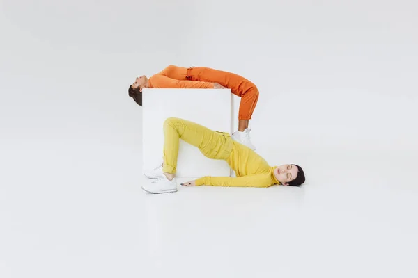 Two women on white cube — Stock Photo, Image