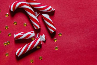 Kırmızı Noel arkaplanı, soyulmuş şeker kamışı ve konfetiyle