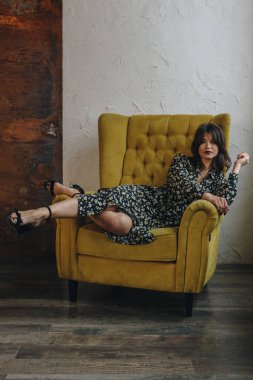 Sarı koltukta oturan güzel genç bayan.