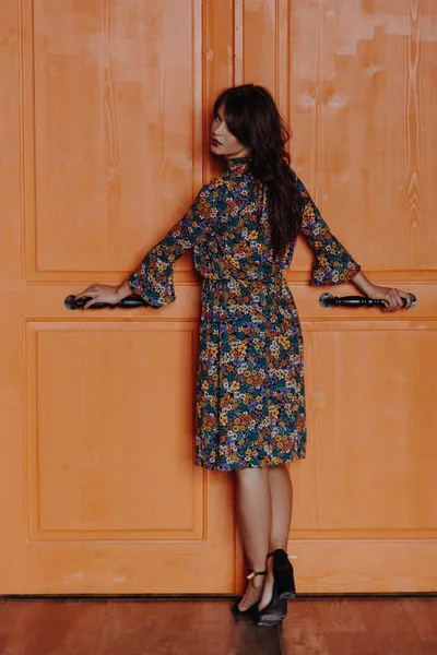 Belle jeune femme debout près de la porte orange — Photo