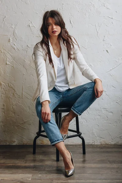 Hermosa joven con blazer blanco y vaqueros azules — Foto de Stock