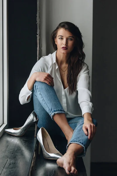 Hermosa mujer joven con blusa blanca y vaqueros azules — Foto de Stock