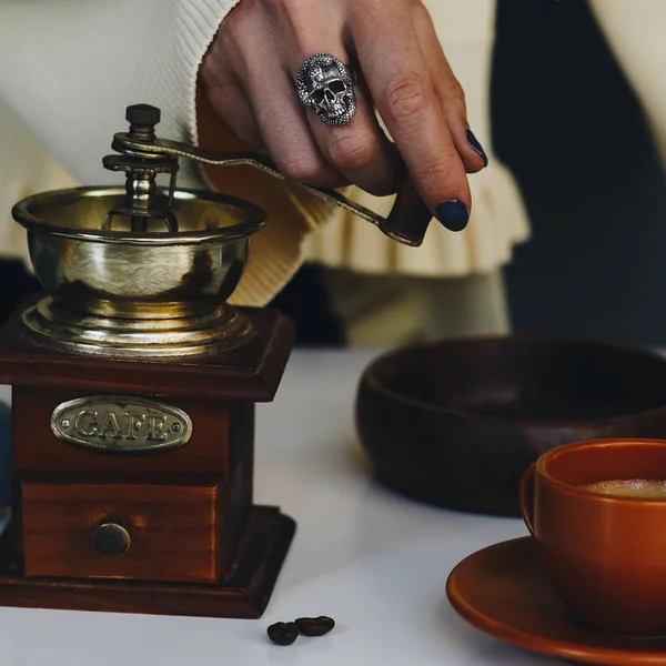 Vrouw hand met zilveren ring met behulp van vintage houten koffiemolen — Stockfoto