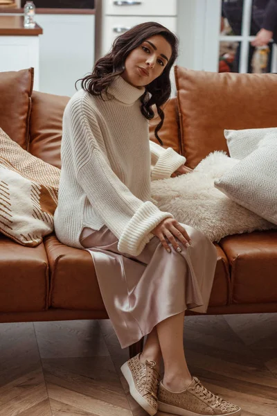 Schöne junge Frau sitzt auf der Couch — Stockfoto