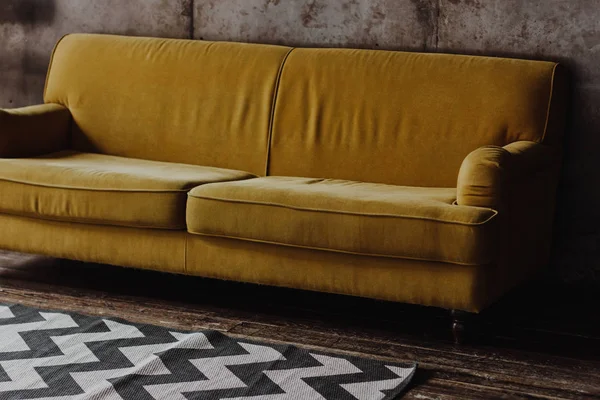 Sárga bársony kanapé tetőtéri szobában — Stock Fotó