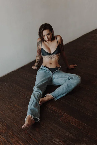 Sexy Woman Tattoos Wearing Lingerie Jeans Sitting Floor — Stock Photo, Image