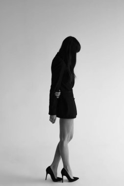 Beyaz arka planda ceket giyen güzel genç bir kadın.