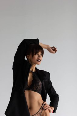 Beyaz arka planda ceket giyen güzel genç bir kadın.