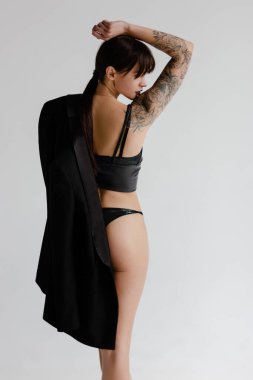 Beyaz arka planda ceket giyen genç bir kadın.