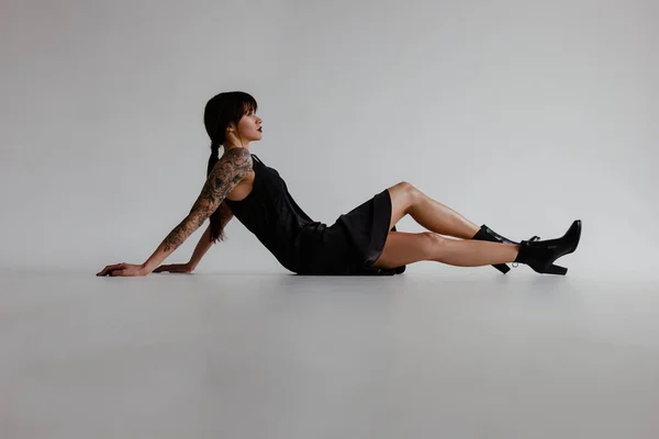 Hermosa Mujer Joven Con Tatuaje Pequeño Vestido Negro Sobre Fondo — Foto de Stock