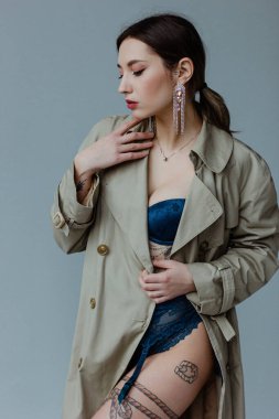 Trençkot giyen güzel genç kadın.