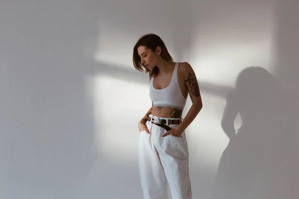 Seksowna Kobieta Tatuażami Ubrana Bawełniany Stanik Białe Dżinsy Białym Tle — Zdjęcie stockowe