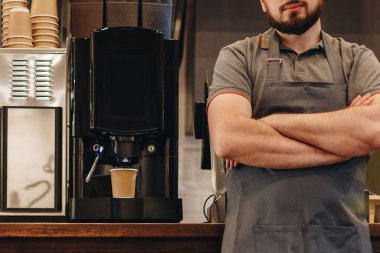Barmen kafede kahve makinesiyle kahve yapıyor.