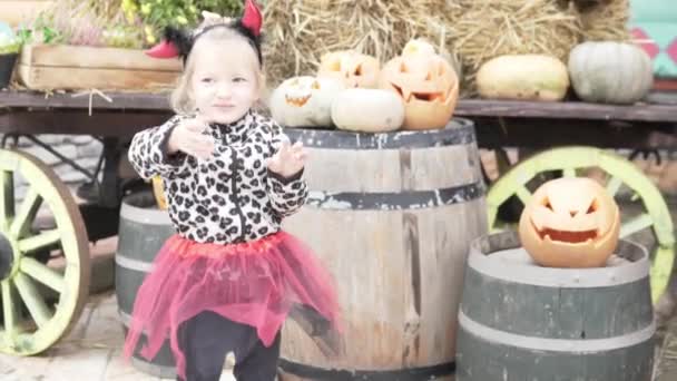 Menina acenando no feriado de Halloween entre abóboras — Vídeo de Stock
