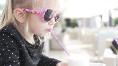 Güneş gözlüklü çocuk milkshake içiyor..