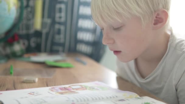 Blond garçon fait des devoirs au bureau de l'école — Video