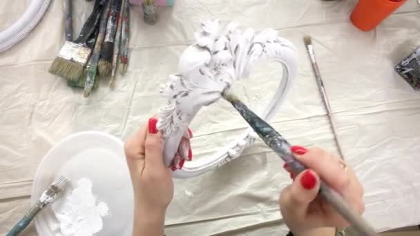 Woman paints a photo frame with white paint. — Stock Video