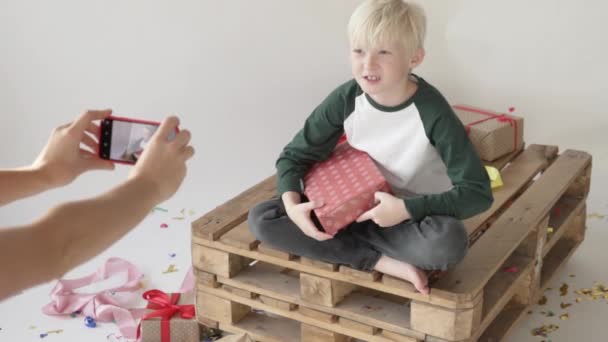 Mamá se quita cómo un niño desempaca un regalo — Vídeos de Stock
