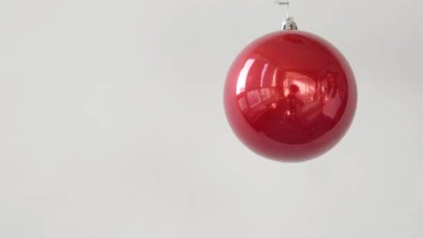 Červené vánoční míč točí na bílém pozadí — Stock video