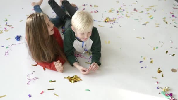 Golden confetti slowly falls on top of the children — Stock Video