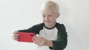 Sarışın çocuk telefonda selfie çekiyor.. 