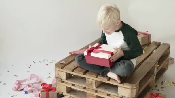 Boy blond opens a box with a gift. — 비디오