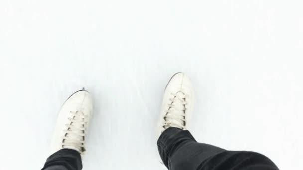 Las mujeres son pies en patines blancos montan en el hielo . — Vídeos de Stock