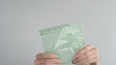 Kadınların elleri gergin bir şekilde ambalaj kağıdındaki kabarık tozu patlatır.