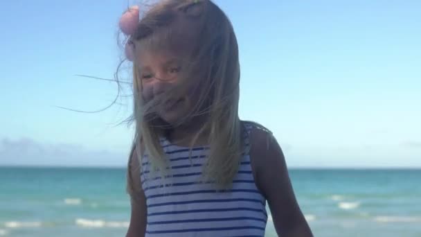 Divertente bambina gioca sulla spiaggia vicino all'oceano — Video Stock