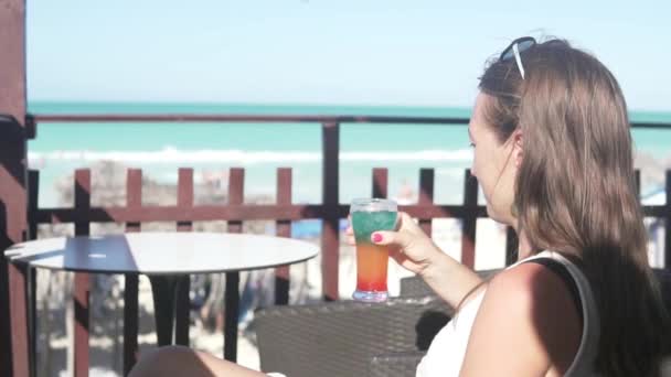 Μια γυναίκα εξετάζει το κοκτέιλ που την έφεραν στο beach bar. — Αρχείο Βίντεο