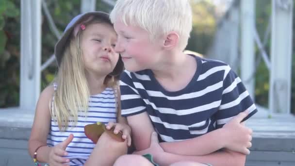 A little girl kisses a boy on the cheek — Stock Video