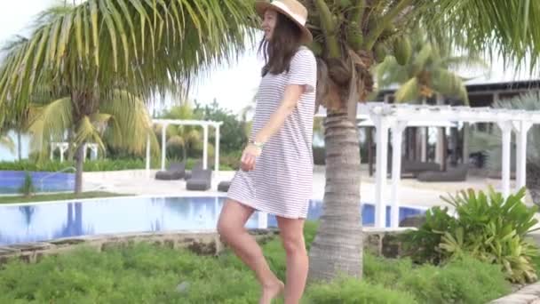 Uma bela mulher de chapéu caminha por um hotel — Vídeo de Stock