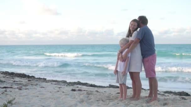 Táta, máma a syn se procházejí po pláži na moři. — Stock video