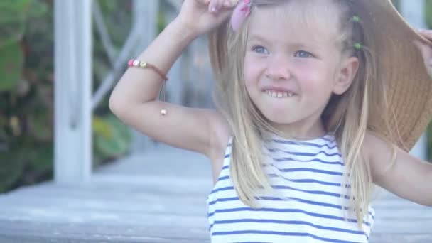 Lustiges kleines Mädchen setzt sich Strandmütze ihrer Mutter auf — Stockvideo