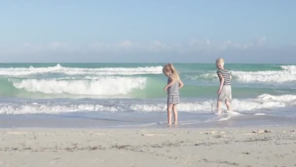 A gyerekek elfutnak a hullám elől. — Stock videók