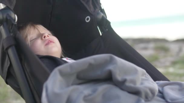 Mała dziewczynka śpi w wózku na plaży.. — Wideo stockowe