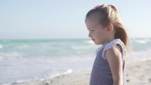 Красивая маленькая девочка смотрит на море — стоковое видео