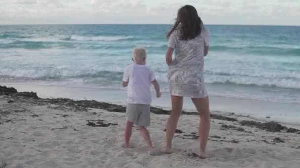 Mama i syn dobrze się bawią tańcząc na plaży nad oceanem — Wideo stockowe