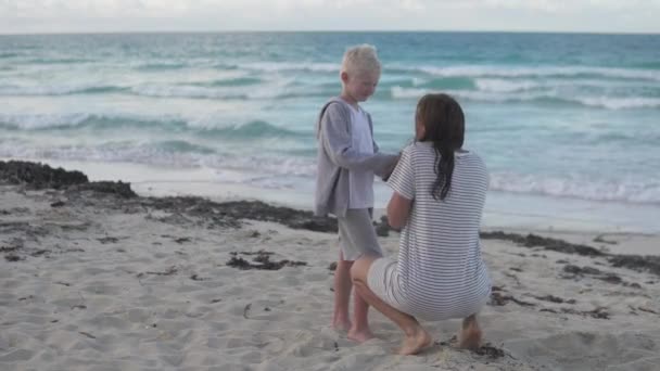 Eine Mutter versucht ihrem Sohn bei einem Spaziergang zuzujubeln — Stockvideo