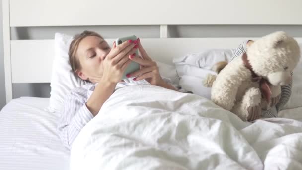 Une femme et sa fille se couchent le matin — Video