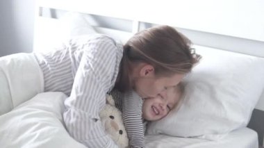 Anne ve küçük kızı sabah yatağında uyandılar.