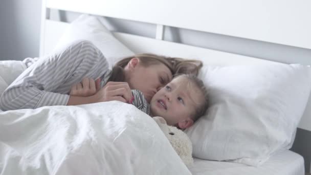 Anya gyengéden megcsókolja és simogatja szeretett kislányát. — Stock videók