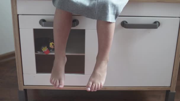Маленька дівчинка рухає ноги — стокове відео