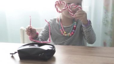 Küçük kız dudaklarını rujla boyadı.