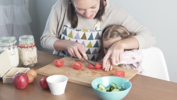 Mom and little daughter cook a vegetable salad together. — 비디오