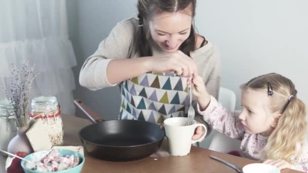 Mamá y su hija cocinan tortilla en casa — Vídeo de stock