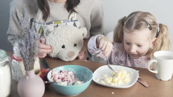 Malá holka jí omeletu v kuchyni.. — Stock video